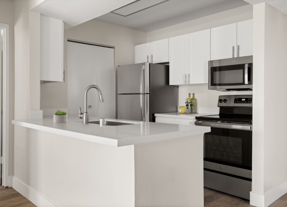 a kitchen with white cabinetry and stainless steel appliances